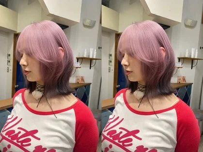 ピンクカラーのミディアムヘアを耳にかけた女性の横顔