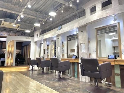 鏡とセット面が並ぶ自然光の入る美容室の店内