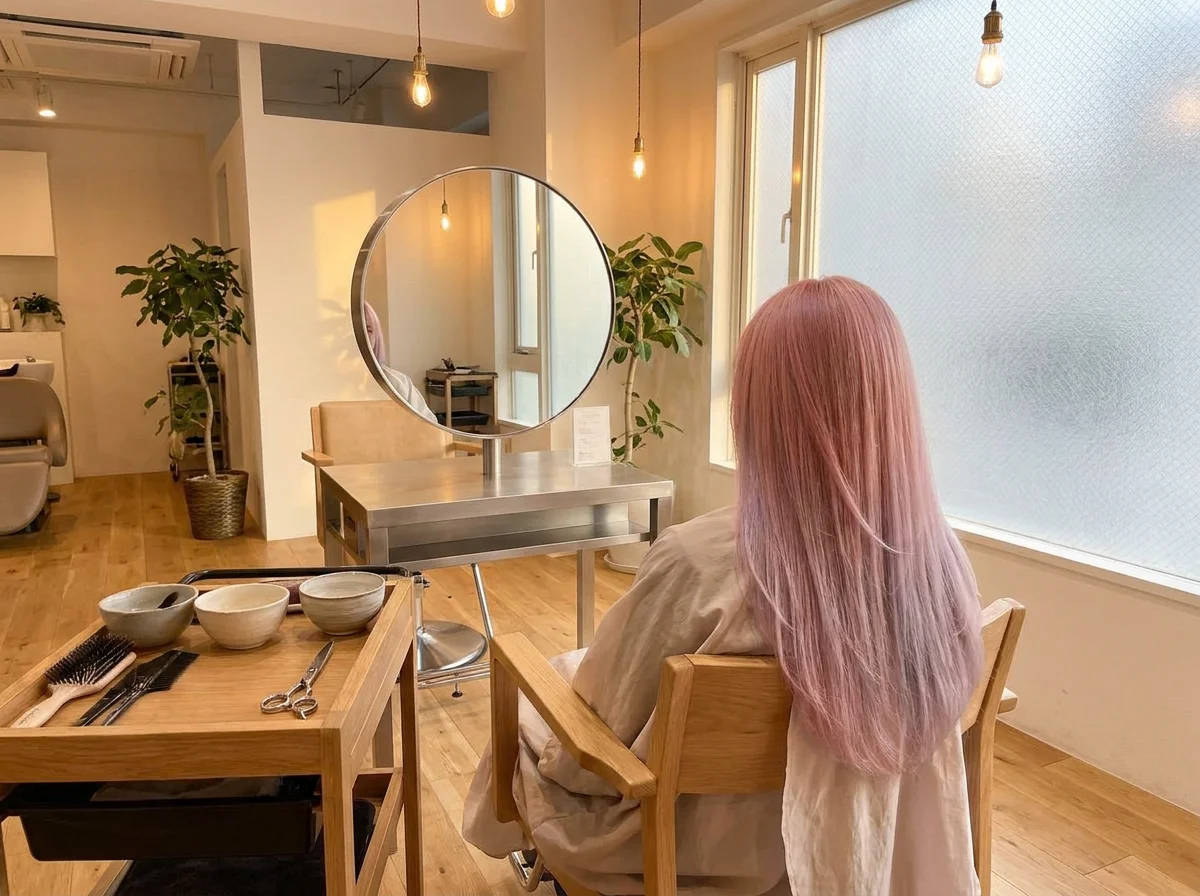 肩から胸元までのロングヘアに淡いピンクからベージュへ変化するカラーを施した後ろ姿